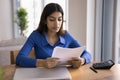 Serious focused young Indian woman reading legal financial document Royalty Free Stock Photo