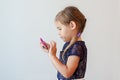 Serious four year old girl tapping smart phone