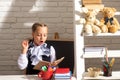 Serious funny school girl reading book in classroom at school. Kid studying at school. Schoolchild doing homework at Royalty Free Stock Photo