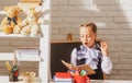 Serious funny school girl reading book in classroom at school. Kid studying at school. Schoolchild doing homework at Royalty Free Stock Photo