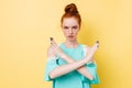 Serious ginger woman in dress showing stop gesture