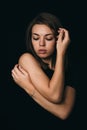 Serious girl on a black background. Beautiful girl in black on a dark background. The girl thinks about her problem Royalty Free Stock Photo