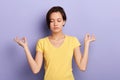 Serious girl doing yoga, isolated blue background