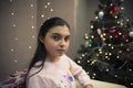 Serious girl on sofa near xmas tree Royalty Free Stock Photo