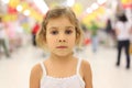 Serious girl standing in big store alone