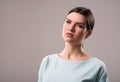 Serious girl standing isolated on grey background