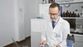 Serious, grey-haired middle age man Ã¢â¬â a dedicated scientist engrossed in reading medical documents in his lab, surrounded