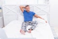 Serious guy in cozy pajamas resting in bed in morning, wakeup Royalty Free Stock Photo