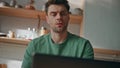 Serious guy face working laptop at kitchen closeup. Frowning man watching screen Royalty Free Stock Photo