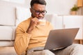 Serious Guy Reading News On Laptop Drinking Coffee At Home Royalty Free Stock Photo