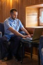 Serious handsome arabian man with beard is using laptop, reading email, typing on keyboard in cafe Royalty Free Stock Photo