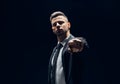 Serious handsome man in black suit pointing his finger to you and camera isolated on dark background Royalty Free Stock Photo