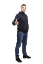 Serious handsome young man in blue hoodie and full-length jeans. Isolated over white background. Royalty Free Stock Photo