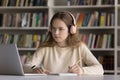 Serious hardworking smart student girl in wireless headphones