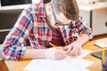 Serious hardworking student sitting at the desk and drawing blueprint Royalty Free Stock Photo