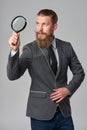 Serious hipster business man with magnifying glass