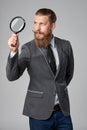 Serious hipster business man with magnifying glass