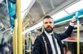 Hipster businessman inside the subway in the city, travelling to work.