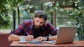 Serious hipster guy taking down notes in his notebook in a cafe Royalty Free Stock Photo