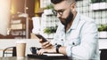 Serious man reading message on smartphone while sitting in cafe at table. Guy checks mail through smartphone. Education. Royalty Free Stock Photo