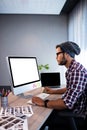 Serious hipster working at computer desk Royalty Free Stock Photo