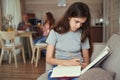 Serious homeschooler learning while her parents communicating in kitchen Royalty Free Stock Photo