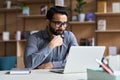 Serious indian business man working or studying on laptop computer. Royalty Free Stock Photo