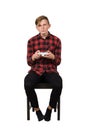 Serious intent teen guy seated on chair playing video games isolated over white background. Boy stand all ears holding joystick