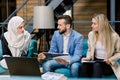 Serious international diverse business team, man and two women, discuss brainstorming financial result and share ideas Royalty Free Stock Photo