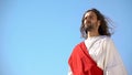 Serious Jesus Christ in white robe looking at humanity from heaven, religion Royalty Free Stock Photo