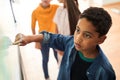 Serious kid writing at the whiteboard using his finger Royalty Free Stock Photo