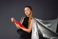 Serious lady, superhero in a gray cloak , holding documents in red folder on a gray background