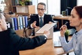 Serious lawyer gives adult man to sign document on divorce. Couple going through divorce signing papers.