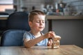 Serious little boy playing board game with wooden turret