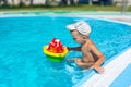 Serious little boy is playing with a toy ship in the pool Royalty Free Stock Photo