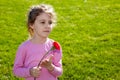 Serious little girl with carnation stands Royalty Free Stock Photo