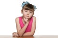 Serious little girl at the desk Royalty Free Stock Photo