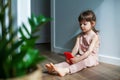 Serious little girl with mobile phone sitting alone on a floor Royalty Free Stock Photo