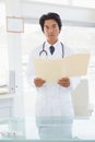 Serious looking doctor with medical files Royalty Free Stock Photo