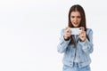 Serious-looking pressured and focused, determined brunette girl trying pass difficult level on mobile game, playing Royalty Free Stock Photo