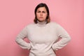 Serious looking woman with her hands on her hips against pink background Royalty Free Stock Photo