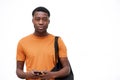 Serious looking young black man with bag and mobile phone against isolated white background Royalty Free Stock Photo