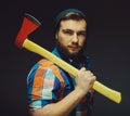 Serious lumberjack. Confident young bearded man holding a big axe