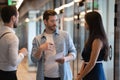 Serious male business leader instructing diverse employees standing in office