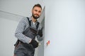 Serious male electrician installing power socket in the apartment and using screwdriver Royalty Free Stock Photo