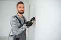 Serious male electrician installing power socket in the apartment and using screwdriver Royalty Free Stock Photo