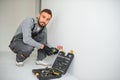 Serious male electrician installing power socket in the apartment and using screwdriver Royalty Free Stock Photo