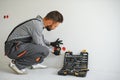 Serious male electrician installing power socket in the apartment and using screwdriver Royalty Free Stock Photo