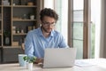 Serious male freelancer in glasses working at homeoffice