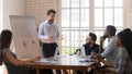 Serious male coach give flip chart presentation to diverse employees Royalty Free Stock Photo